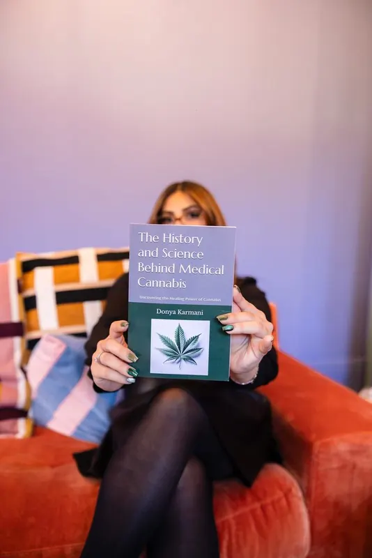 A Women's Circle guest holding up a book on the history and science behind medical cannabis