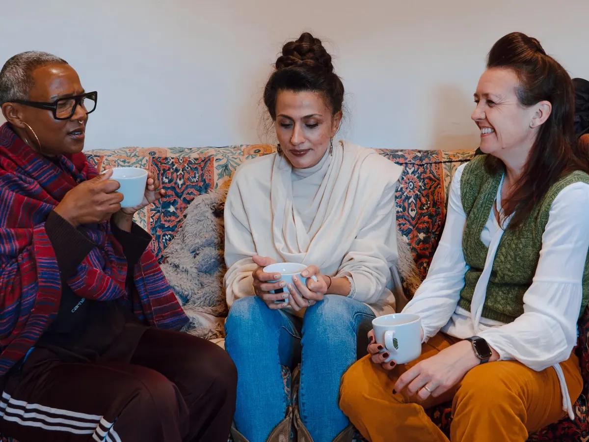 Three women sharing tea and conversation on a sofa at Circle 2.0, The Cycle Edition